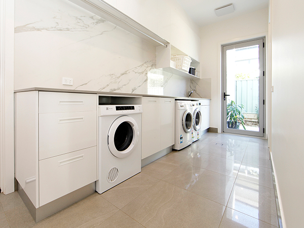 Spacious laundry room with sleek laundry cabinets for organised storage and stylish decor.